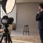 On-site team headshot setup with softbox lighting, a gray backdrop, and a camera on a tripod in a bright office